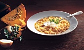 Pumpkin risotto with parmesan cheese, onions and parsley on plate