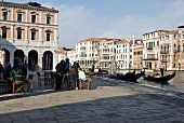 People sitting in outdoors restaurant beside Grand Canal, Venice, Italy