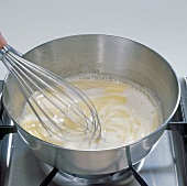 Butter slices being stirred with whisk in saucepan, step 6