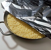 Close-up of rice in pan covered with foil, step 5