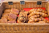 Croissants, Rosinenschnecken und Taschen im Korb, Preisschilder