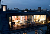 Illuminated penthouse apartment with glass windows at night
