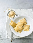 Ravioli and parmesan with skimmer on plates