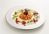 Salmon tartare with caviar and small salad on plate