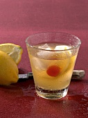 Whiskey sour drink with halved lemon in glass