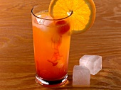 Tequila sunrise drink in glass with lemon slice on rim