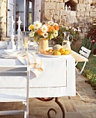 Gedeckter Tisch: Blumen, Obst, Kerzenleuchter, ländlich