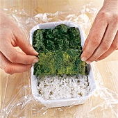 Sushi - Reisschicht wird mit Nor iblatt bedeckt