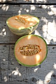Halved galia melon on wooden surface