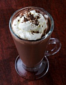 Hot chocolate with cream and chocolate sprinkles in glass