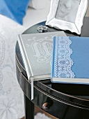 Blaues Buch m. Spitzenbordüre auf kleinem Beistelltisch