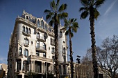 Fassade des Hotels Casa Fuster in Barcelona, Palmen, weiß.
