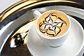 Tasse Kaffee, Milchschaum mit Schokoladenblume verziert