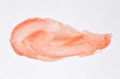Close-up of scribbled lip gloss on white background
