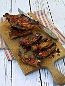 Barbecued spare ribs, jerk pork ribs and knife on chopping board