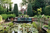 Garten in England mit Brunnen und Wasserlauf, Bronzereliefs am Wasser