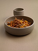 Duck breast with mango, carrots and spring onions in bowl