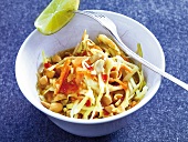 Cabbage and peanut salad with carrots and lime in bowl