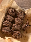 Nut cookies with chocolate filling on baking paper