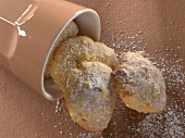 Apple and raisin biscuits with powdered sugar on brown background