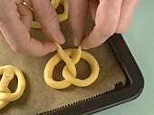 Close-up of hand forming pattern from dough for preparation of biscuits, step 4