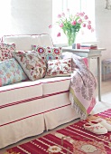 Beige sofa with colourful embroidered silk cushions