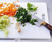 Vegetables chopped on cutting board for herb sauce, step 1