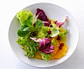 Green salad with orange vinaigrette in bowl