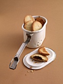 Espresso and almond biscuits in container on brown background