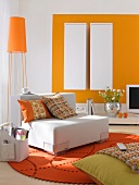 Wohnzimmer in orange-weiß, Stehlampe , runder Filzteppich,2 Hängeschränke