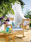Garden terrace with rocking chairs, canopy and colourful pillows