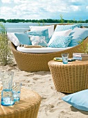 Sofainsel aus Kunststoffgeflecht mit blauen und weißen Kissen, Strand