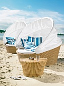 Two sofa islands with canopy and wicker table on beach