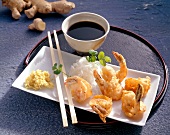 Deep fried prawn with chopsticks on plate and bowl of radish and ginger dip