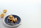 Ragout of shrimp and vegetables on plate with noodle basket, copy space