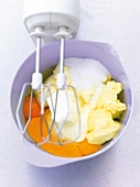 Backzuaten in Schüssel : Eier, Butter, Zucker, Rührbesen