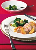 Pork with cider sauce, broccoli and walnuts on plate