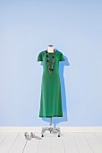 grünes Seidenkleid auf einem Kleiderständer
