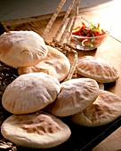 Close-up of six pita bread in basket with red pepper salad