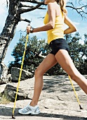 Woman wearing sportswear nordic walking with poles