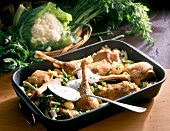 Goose legs with vegetables and sour cream in baking dish