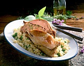 Close-up of stuffed pigeon with peas risotto in serving dish