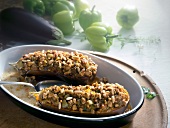 Two stuffed eggplants with chicken chilli and pine nut in serving dish