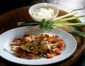 Close-up of chicken with lemongrass, chopped nuts and rice on plate