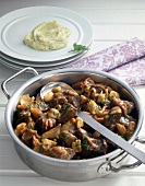 Ostrich stew with mushrooms and spoon in pan