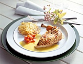 Grilled chicken breast with hash browns and peppers sauce on plate