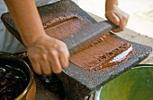Buch der Schokolade, Frau zermahlt Kakao zur geschmeidigen Masse