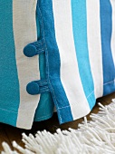 Close-up of blue and white striped sofa throw with buttons