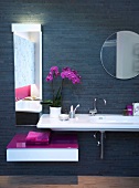 White long sink against black wall with two mirrors