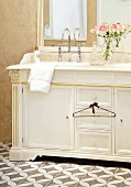 Waschbecken im weißen, alten Holzsch rank, großer Spiegel, Rosenstrauß